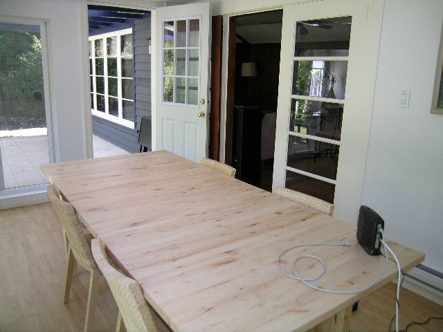 Dining area with wooden table, hardwood floors, and French doors leading to patio. - 1250 Seymour Blvd, North Vancouver