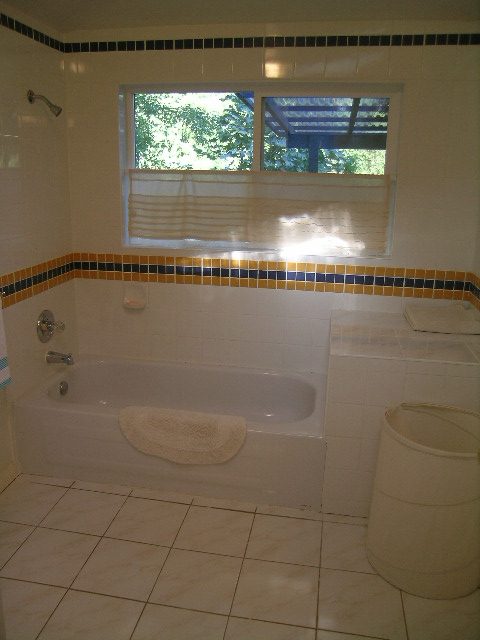 Bright bathroom with large tub, tiled floor, and window view. - 1250 Seymour Blvd, North Vancouver