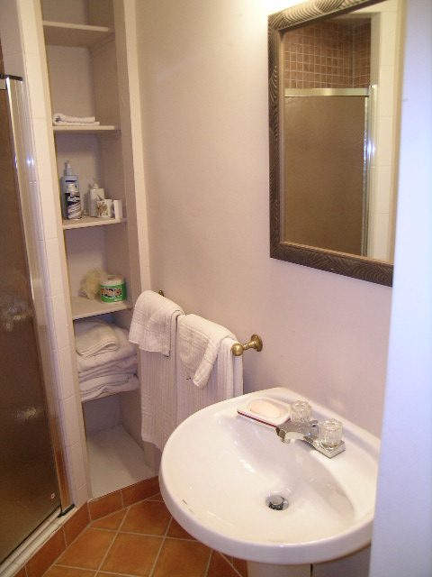 Bright bathroom with white sink, mirror, and neatly folded towels. - 1250 Seymour Blvd, North Vancouver
