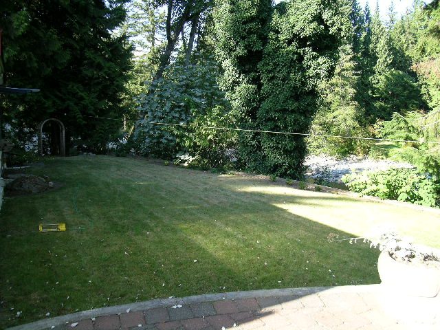 Lush garden with greenery and brick patio. - 1250 Seymour Blvd, North Vancouver