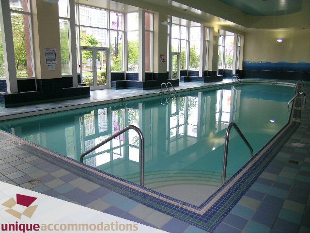 Spacious indoor pool with tiled edges and city view. - 3601-193 Aquarius Mews, Vancouver Downtown