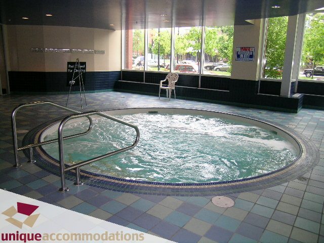 Spacious indoor hot tub with tiled surroundings and city view. - 3601-193 Aquarius Mews, Vancouver Downtown