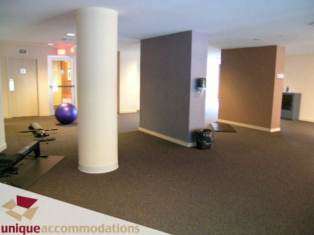 Spacious living room with modern decor, large windows, and a fitness ball. - 3601-193 Aquarius Mews, Vancouver Downtown