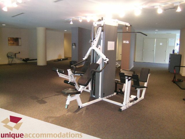 Fitness room with weight machines and carpeted floor. - 3601-193 Aquarius Mews, Vancouver Downtown