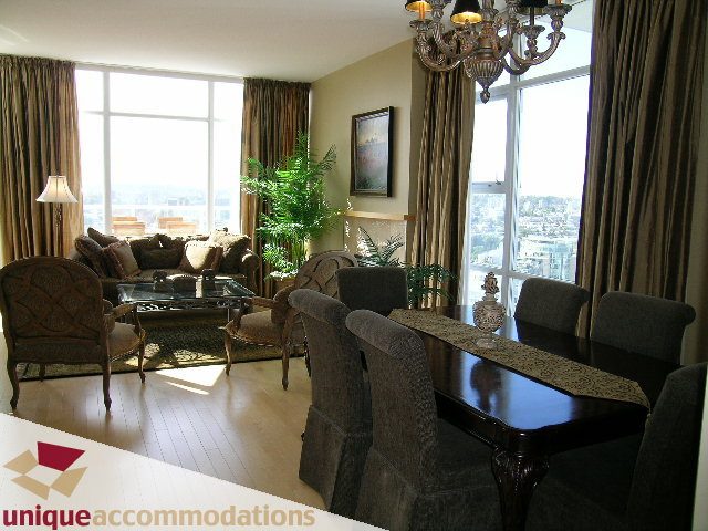 Spacious living room with city view, large windows, and elegant furnishings. - 3601-193 Aquarius Mews, Vancouver Downtown