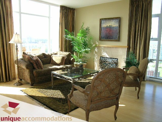 Spacious living room with hardwood floors, city view, and comfortable furniture. - 3601-193 Aquarius Mews, Vancouver Downtown