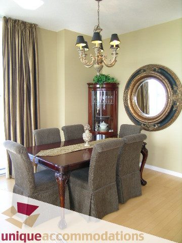 Furnished dining room with hardwood floors, chandelier, and large mirror. - 3601-193 Aquarius Mews, Vancouver Downtown