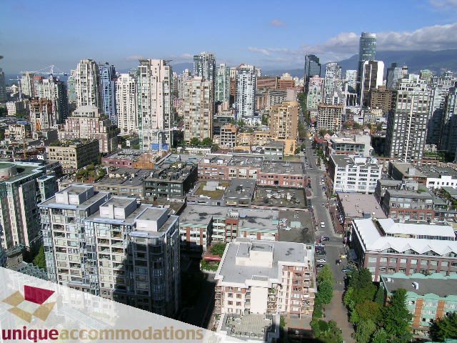 Bright living room with city view and modern furnishings. - 3601-193 Aquarius Mews, Vancouver Downtown
