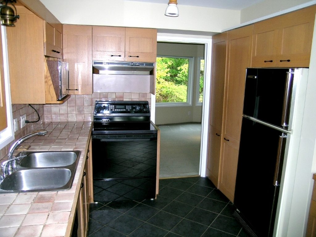 Bright kitchen with wooden cabinets, stainless steel appliances, and a window view. - 2331 Hyannis Drive, North Vancouver
