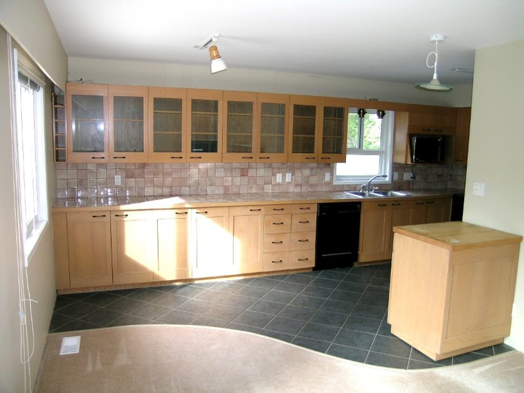 Bright kitchen with light wood cabinets, granite countertops, and a tiled backsplash. - 2331 Hyannis Drive, North Vancouver