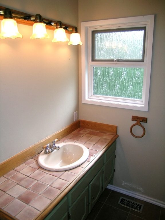 Modern bathroom with a window, wooden countertop, and a sink. - 2331 Hyannis Drive, North Vancouver