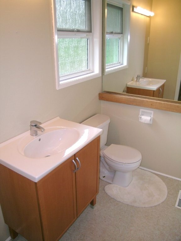 Spacious bathroom with dual sinks, wooden cabinets, and a large mirror. - 2331 Hyannis Drive, North Vancouver