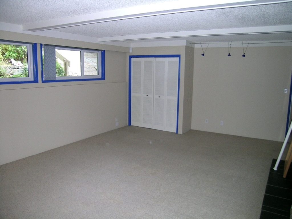 Spacious den with carpeted floor, large windows, and closet, perfect for relaxation or office space. - 2331 Hyannis Drive, North Vancouver