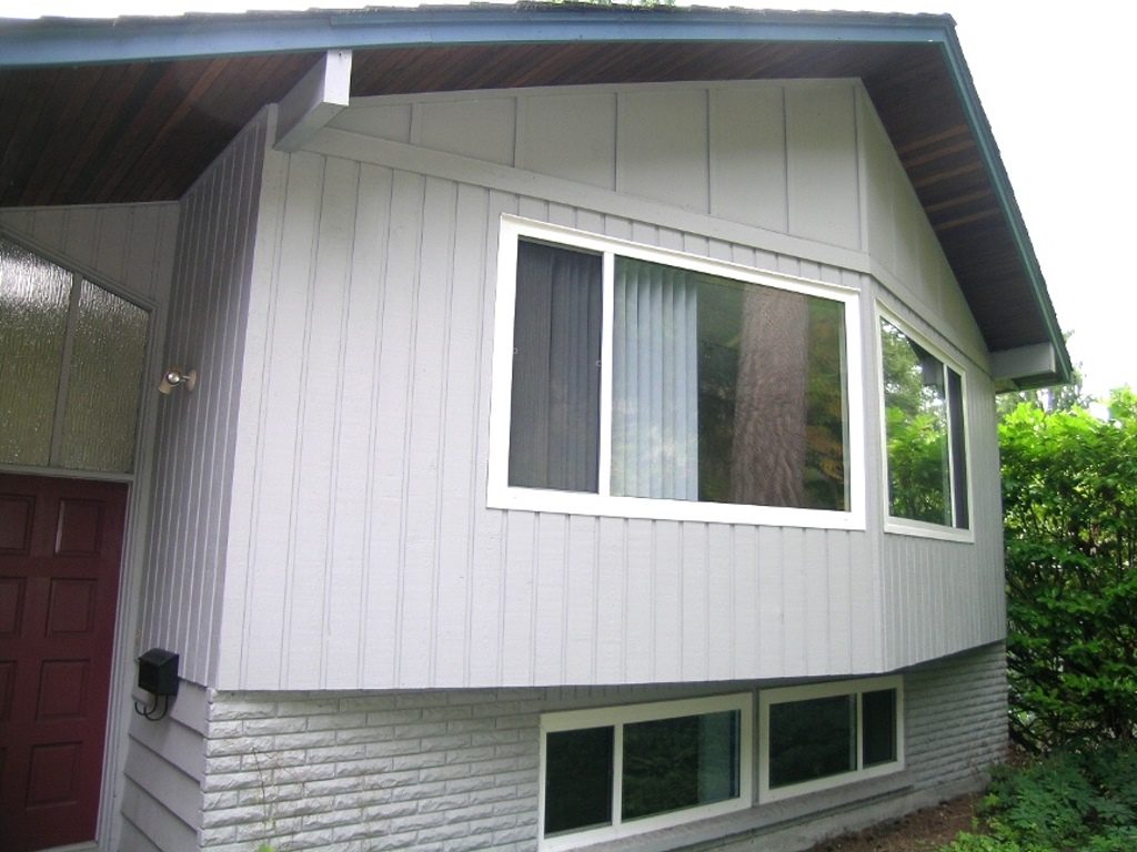 Spacious 3-bedroom + den house with modern siding and large bay windows, offering a cozy and inviting atmosphere.