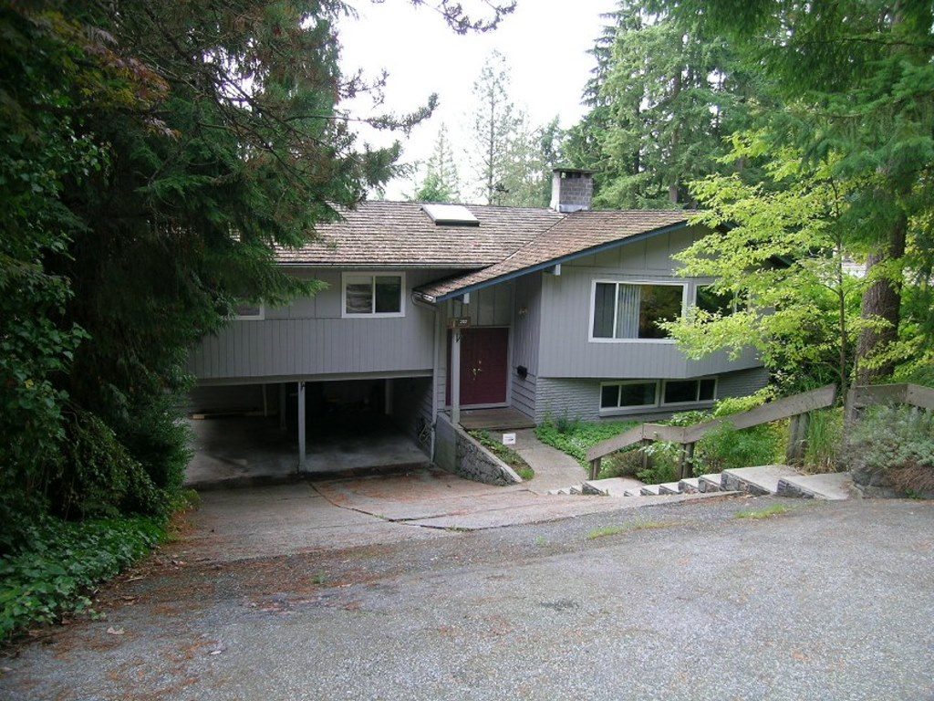 Spacious 3-bedroom + den house with a modern design, surrounded by lush greenery and a large driveway. - 2331 Hyannis Drive, North Vancouver