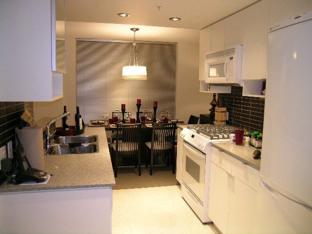 Bright kitchen with granite countertops, stainless steel appliances, and a dining area in the background. - 930 Beatty Street, Vancouver Downtown
