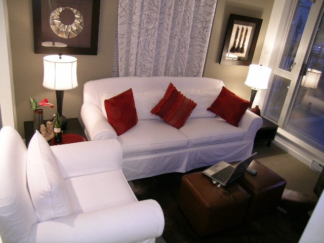 Furnished living room with white couch, red pillows, and city view. - 930 Beatty Street, Vancouver Downtown