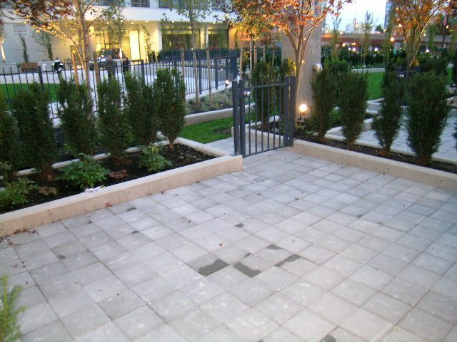 Patio with stone pavers, trees, and a black metal gate. - 930 Beatty Street, Vancouver Downtown