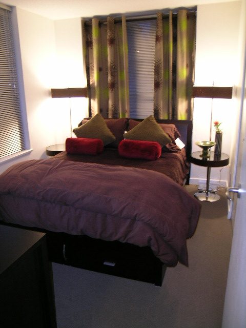 Furnished bedroom with purple bedding and green curtains, cozy and inviting. - 930 Beatty Street, Vancouver Downtown