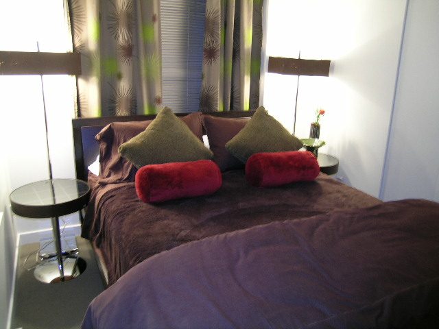 Furnished living room with purple couch, green pillows, and modern decor. - 930 Beatty Street, Vancouver Downtown