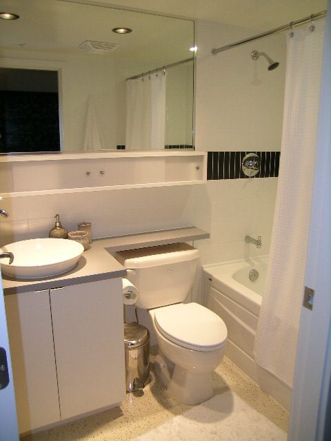 Bathroom with white fixtures, tiled walls, and a shower. - 930 Beatty Street, Vancouver Downtown
