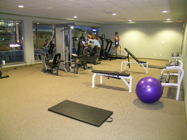 Fitness room with cardio equipment, weights, and exercise balls; city view through large windows. - 930 Beatty Street, Vancouver Downtown