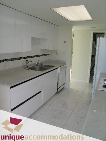 Bright kitchen with white cabinets, granite countertops, and tiled floor. - PH1 - 125 West 2nd Street, North Vancouver