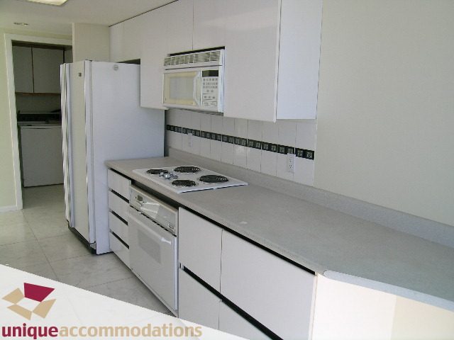 Bright kitchen with white countertops, modern appliances, and a clean, minimalist design. - PH1 - 125 West 2nd Street, North Vancouver