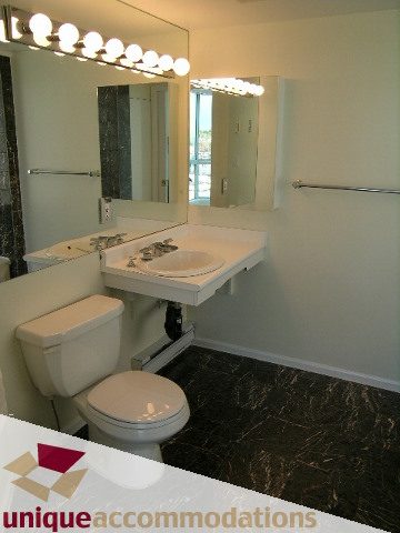Bathroom with marble countertop and wall-mounted lights. - PH1 - 125 West 2nd Street, North Vancouver