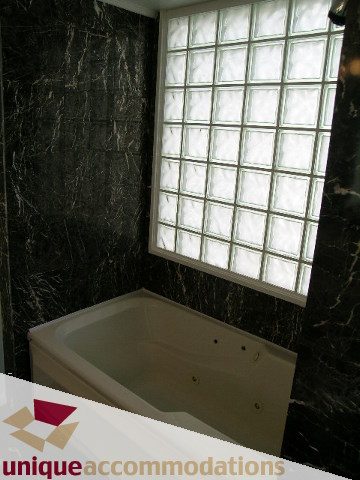 Spacious bathroom with marble walls and glass block window. - PH1 - 125 West 2nd Street, North Vancouver