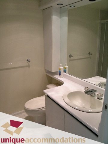 Bathroom with modern sink, countertop, and mirror. - PH1 - 125 West 2nd Street, North Vancouver
