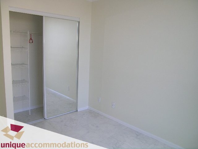 Bright bedroom with sliding closet doors and marble floor. - PH1 - 125 West 2nd Street, North Vancouver