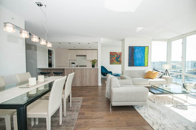 Bright living room with city view and glass dining table, modern furnishings. - 1703-1067 Marinaside Crescent, Vancouver Downtown