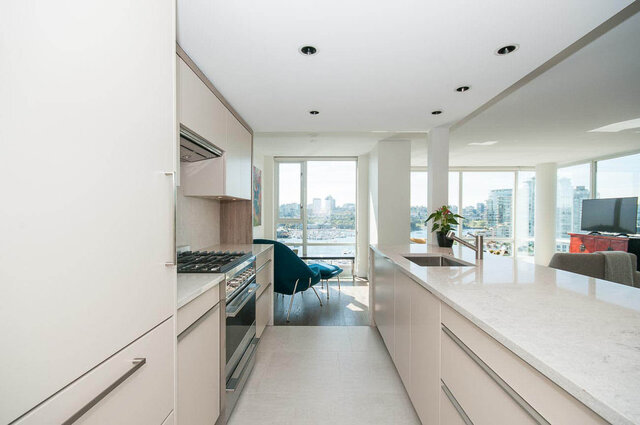 Bright kitchen with white marble countertops and panoramic city views. - 1703-1067 Marinaside Crescent, Vancouver Downtown