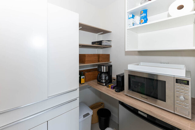 A clean, modern kitchen with stainless steel appliances and white cabinetry - 1703-1067 Marinaside Crescent, Vancouver Downtown