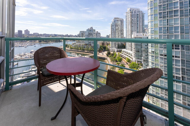 Balcony with red table and wicker chairs overlooking Vancouver's waterfront cityscape. - 1703-1067 Marinaside Crescent, Vancouver Downtown