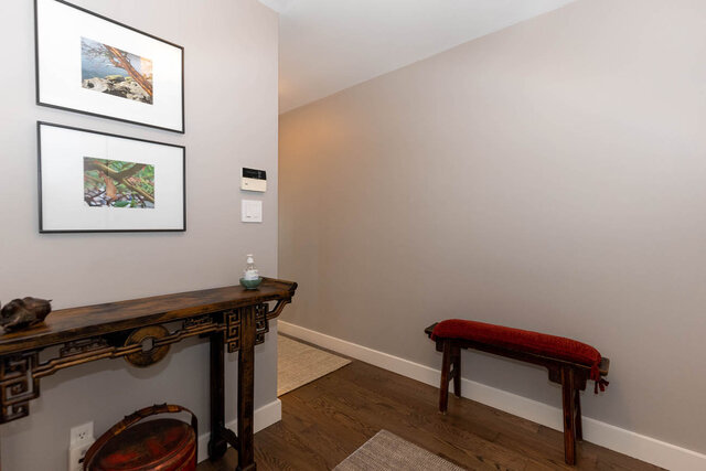 Entryway with hardwood floors and framed coastal artwork above a console table. - 1703-1067 Marinaside Crescent, Vancouver Downtown