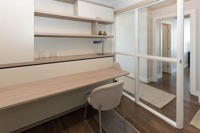 Home office with light wood desk, sliding glass doors, and hardwood flooring. - 1703-1067 Marinaside Crescent, Vancouver Downtown