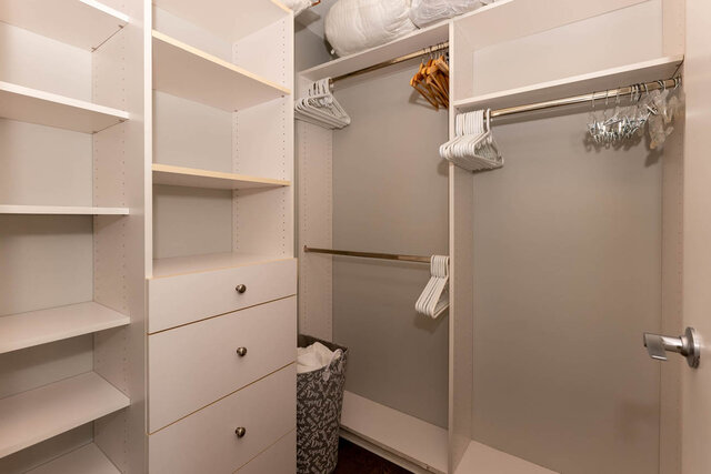 Spacious walk-in closet with white shelving, drawers, and hangers. - 1703-1067 Marinaside Crescent, Vancouver Downtown