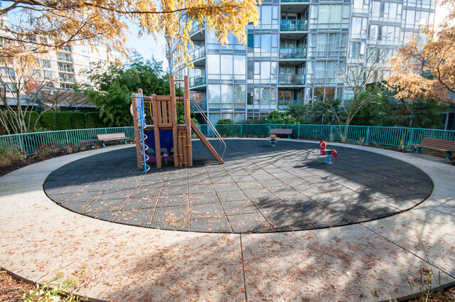 Outdoor courtyard with playground equipment and modern condo backdrop. - 1703-1067 Marinaside Crescent, Vancouver Downtown