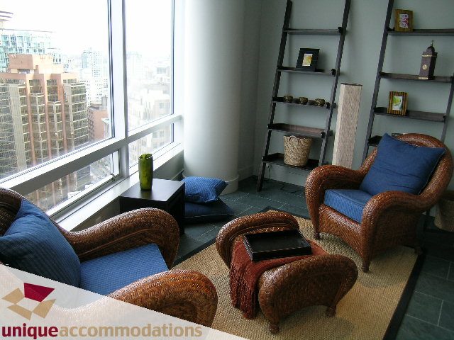 Bright living room with wicker furniture, city view, and modern decor. - 2601 - 1077 West Cordova Street, Vancouver Downtown