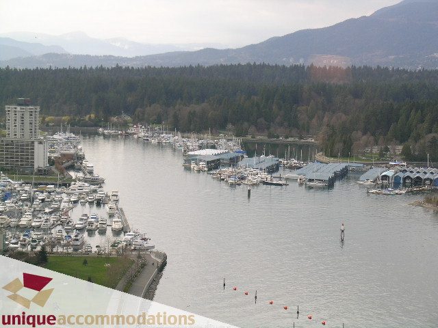 Bright living room with stunning city view and marina, surrounded by lush greenery. - 2601 - 1077 West Cordova Street, Vancouver Downtown