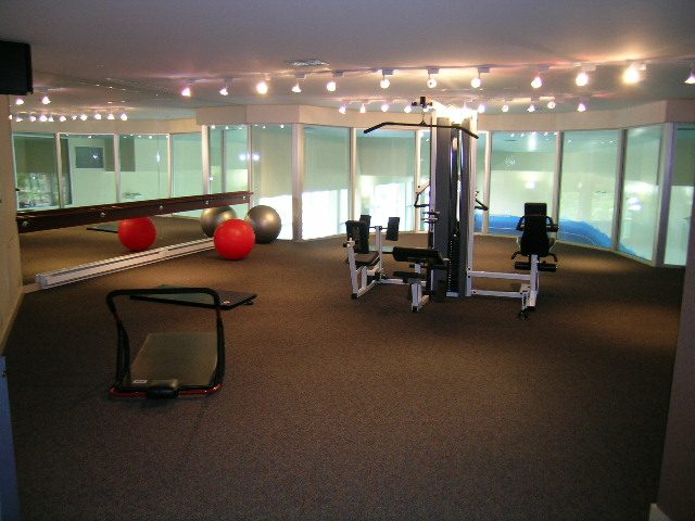 Furnished fitness room with exercise equipment and mirrors, city view. - 1601 - 193 Aquarius Mews, Vancouver Downtown