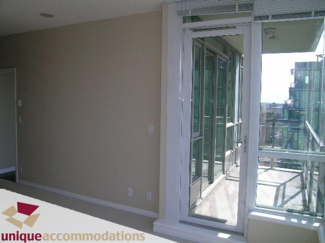 Bright living room with sliding glass doors leading to a city view. - 3401 - 1328 W. Pender Street, Vancouver Downtown
