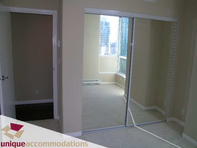 Bright living room with sliding glass doors leading to a balcony, offering a city view. - 3401 - 1328 W. Pender Street, Vancouver Downtown