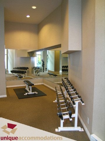 Bright and spacious gym with mirrored walls, dumbbell racks, and exercise equipment. - 3401 - 1328 W. Pender Street, Vancouver Downtown