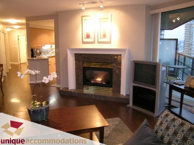 Furnished living room with hardwood floors, city view, and modern fireplace. - 11C - 199 Drake Street, Vancouver Downtown