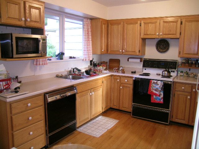 Bright kitchen with light wood cabinets, white countertops, and hardwood floors, perfect for a cozy stay. - 1495 Kings Avenue, West Vancouver