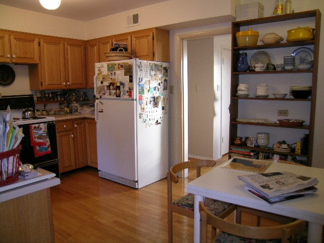Bright kitchen with white countertops, wooden cabinets, and hardwood floors, perfect for a cozy stay. - 1495 Kings Avenue, West Vancouver
