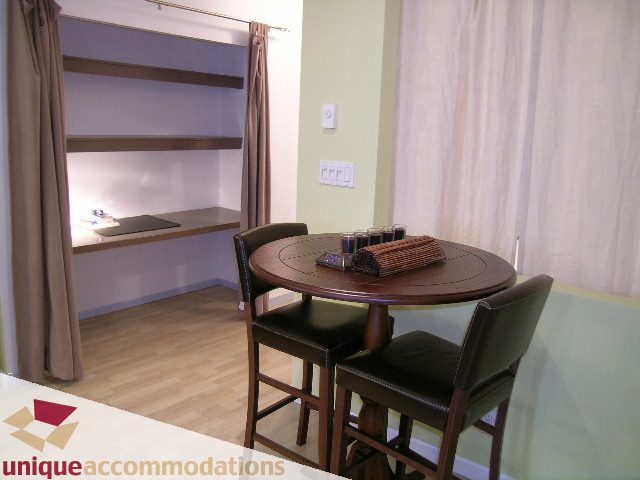 Bright kitchen with wooden bar stools, hardwood floors, and a cozy corner desk setup. - 406 - 1688 Cypress Street, Vancouver West Side